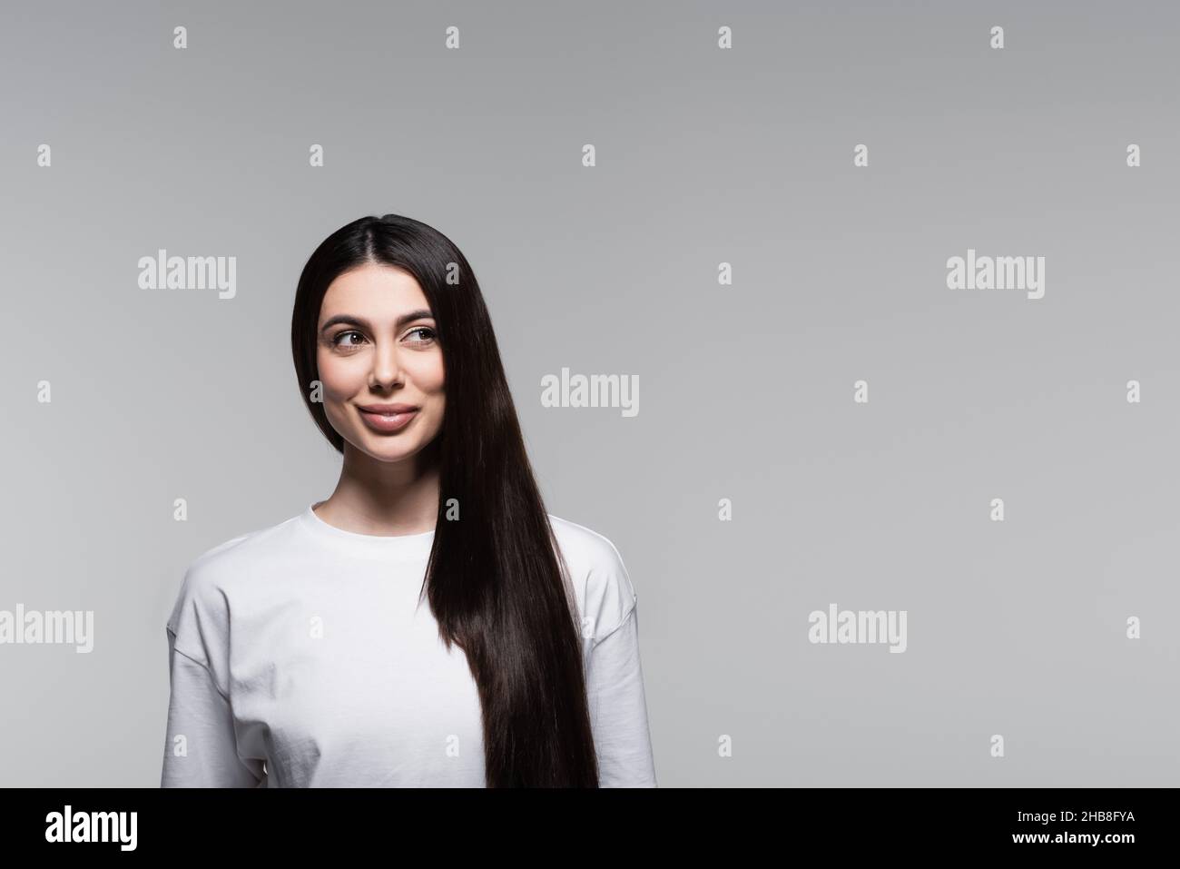 cheerful woman with straight long hair isolated on grey Stock Photo