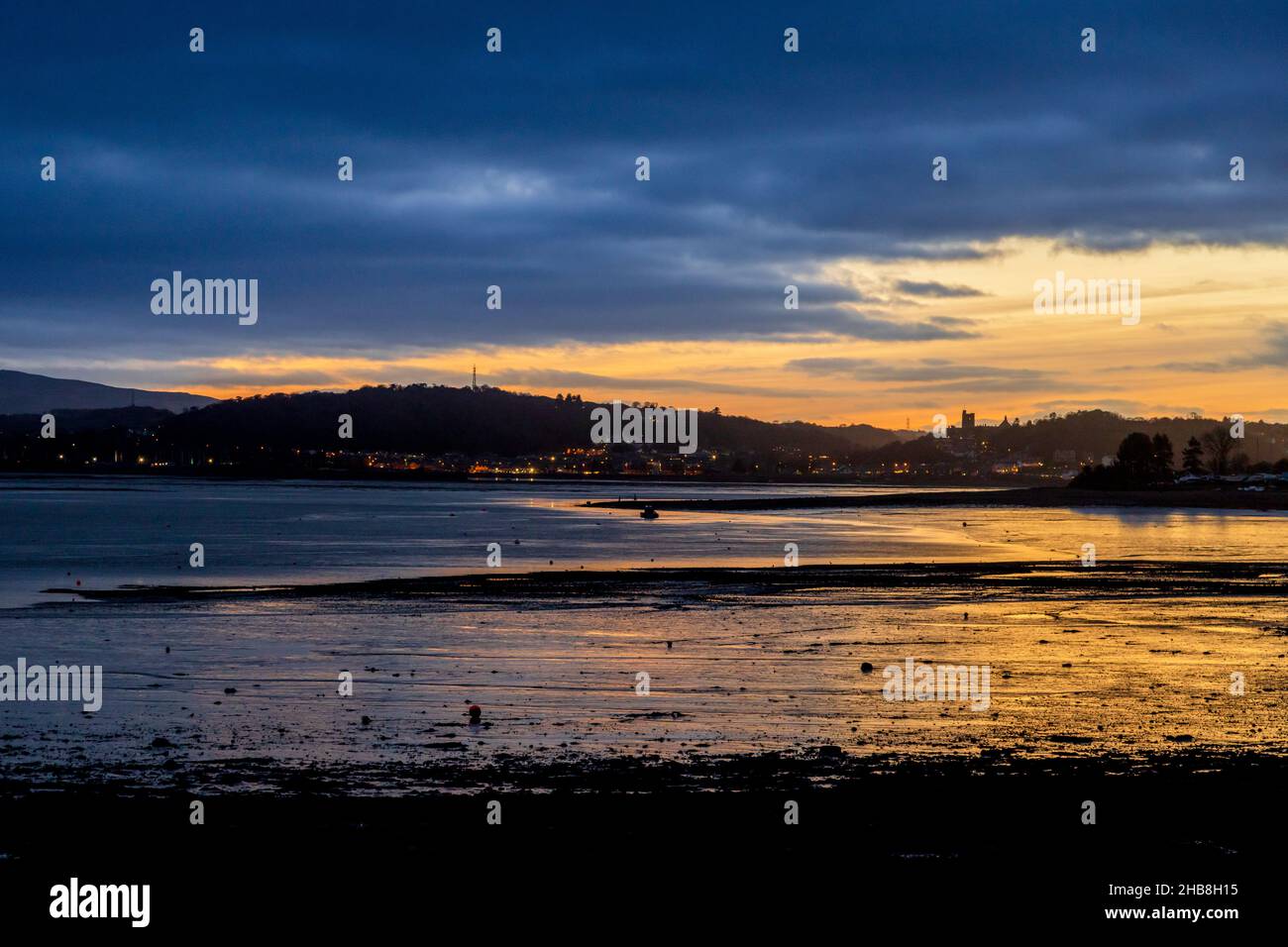 Sunset across the Menai Strait towards Bangor and Penryn Castle from Beaumaris, Isle of Anglesey, North Wales Stock Photo