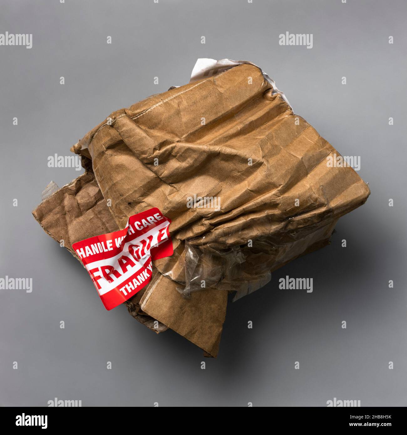Fragile handle with care sticker on crushed package Stock Photo Alamy