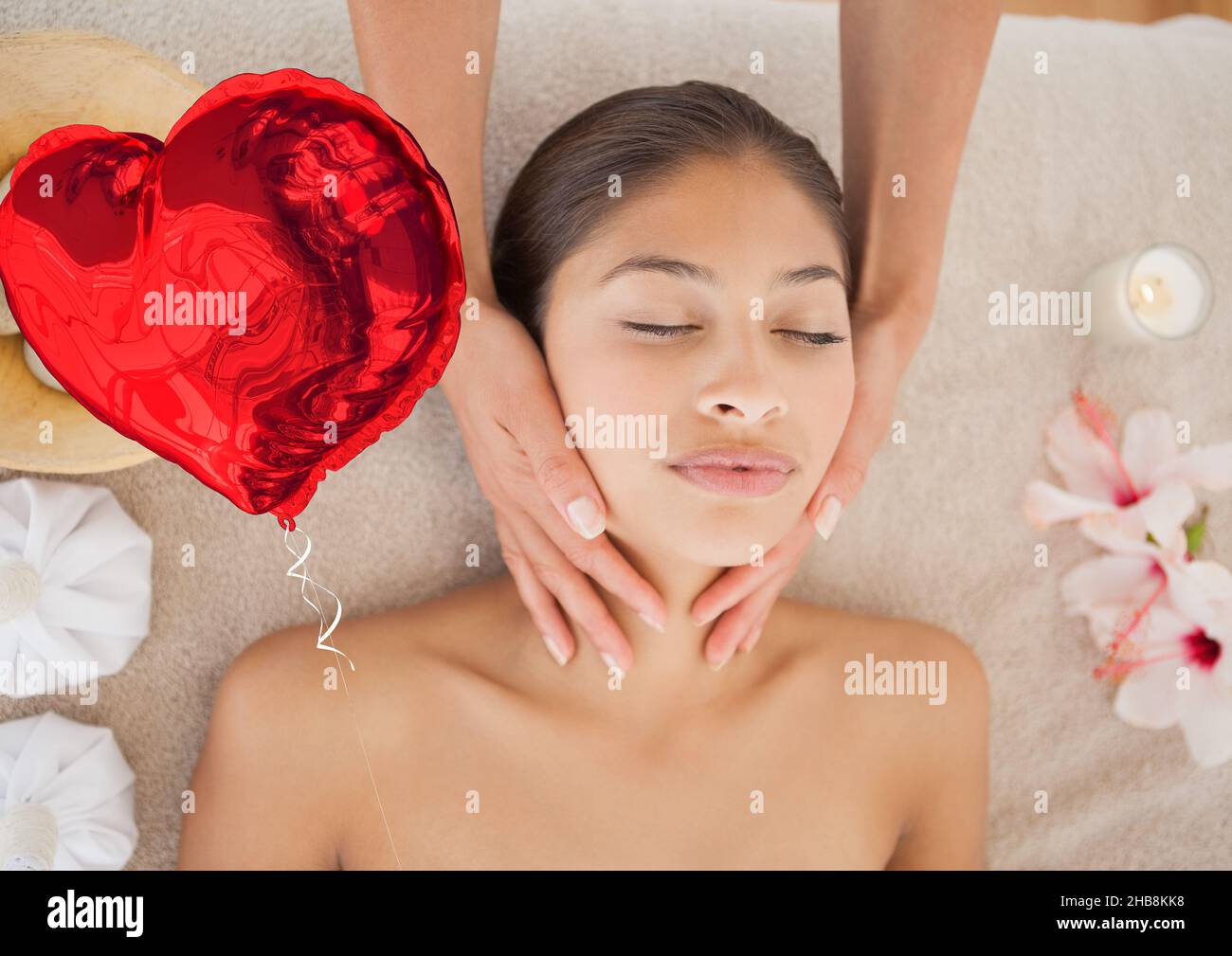Composite image of red heart shaped foil balloon against woman receiving a neck massage at a spa Stock Photo