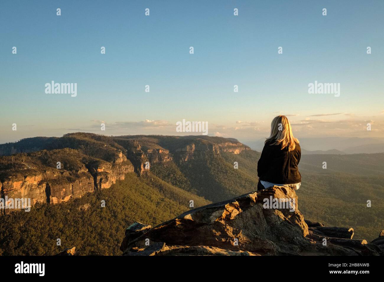 Australia, NSW, Blue Mountains National Park, Rear view of woman looking at view in Megalong Valley at sunset Stock Photo