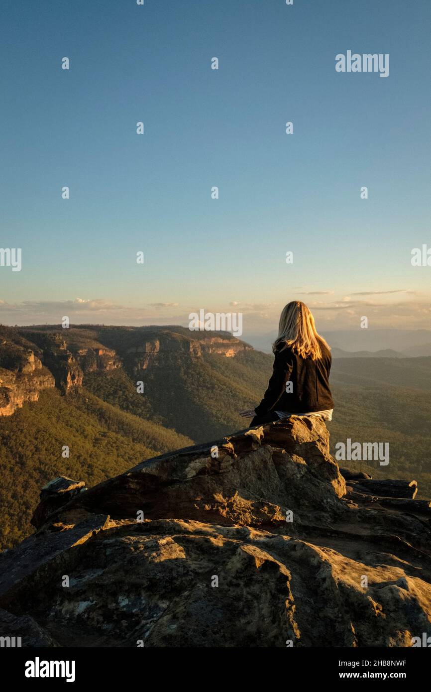 Australia, NSW, Blue Mountains National Park, Rear view of woman looking at view in Megalong Valley at sunset Stock Photo