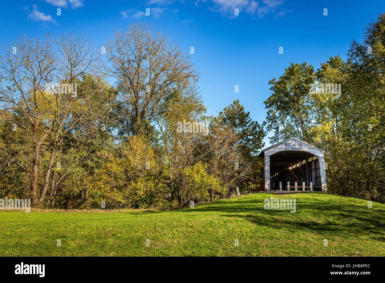 The Neet Covered Bridge crosses Little Raccoon Creek during Autumn leaf color change  near Catlin in Parke County, Indiana. Stock Photo