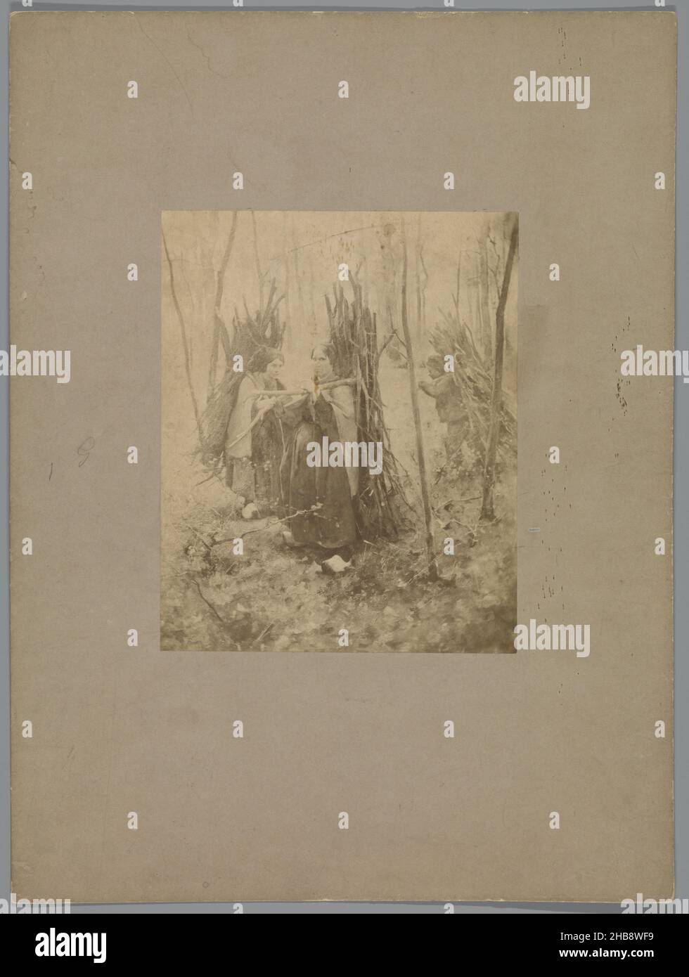 Reproduction after a painting by Willem Witsen of two women and a child with branches on their backs, anonymous, Willem Witsen, Netherlands, c. 1860 - c. 1915, paper, cardboard, albumen print, height 212 mm × width 172 mmheight 427 mm × width 320 mm Stock Photo