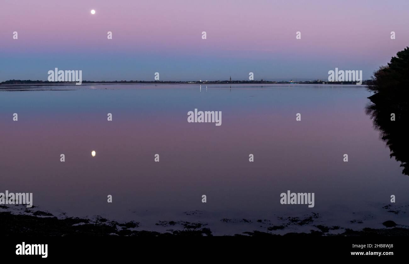 Angus, UK. 17th Dec, 2021. UK Weather, Montrose Basin, Angus, Scotland, UK 17th of Dec 2021: Pictured - The Montrose basin in Angus, as the sunsets and the moon rises to take its place, leading to a dramatic sky filled with colours, as the temperature drops to -1 tonight in Montrose. Credit: Barry Nixon/Alamy Live News/Alamy Live News Stock Photo