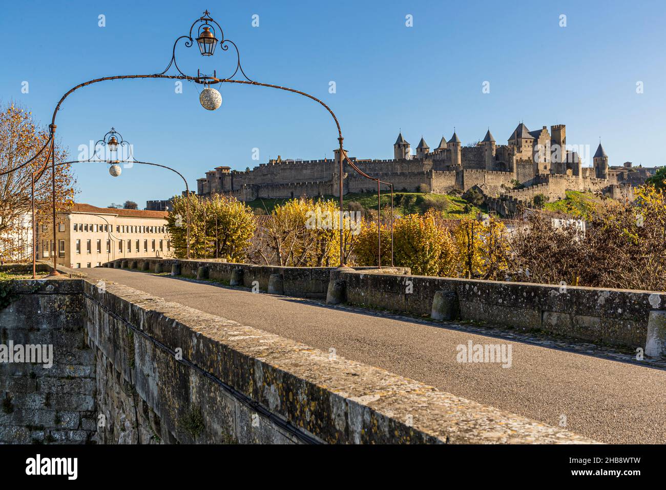 The old town fortress of Carcassonne is located behind the 14th century Pont Vieux, which crosses the river Aude Stock Photo