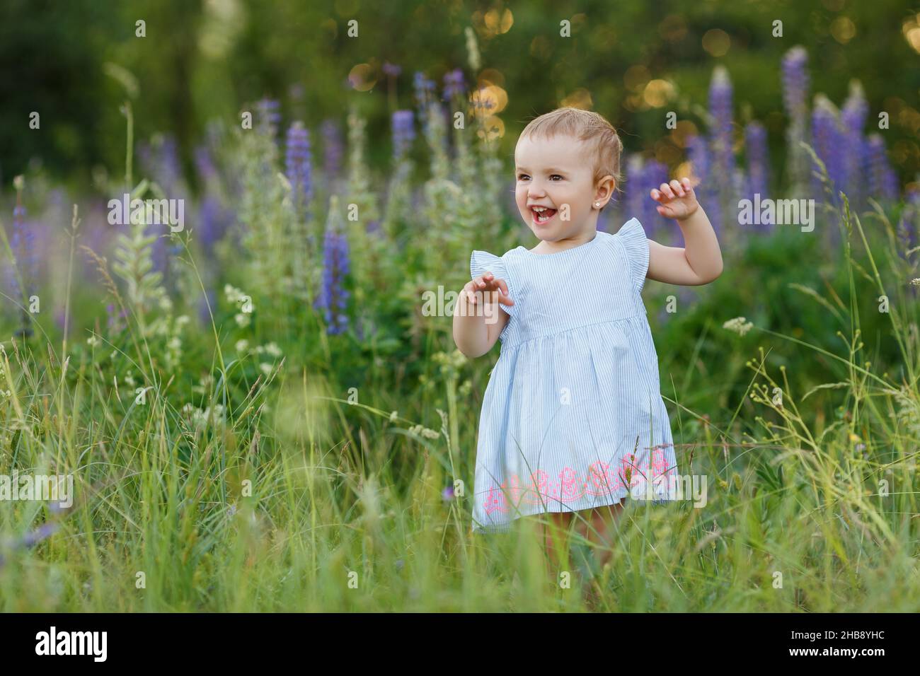 Close up portrait of cute, one year old, little girl in blue dress