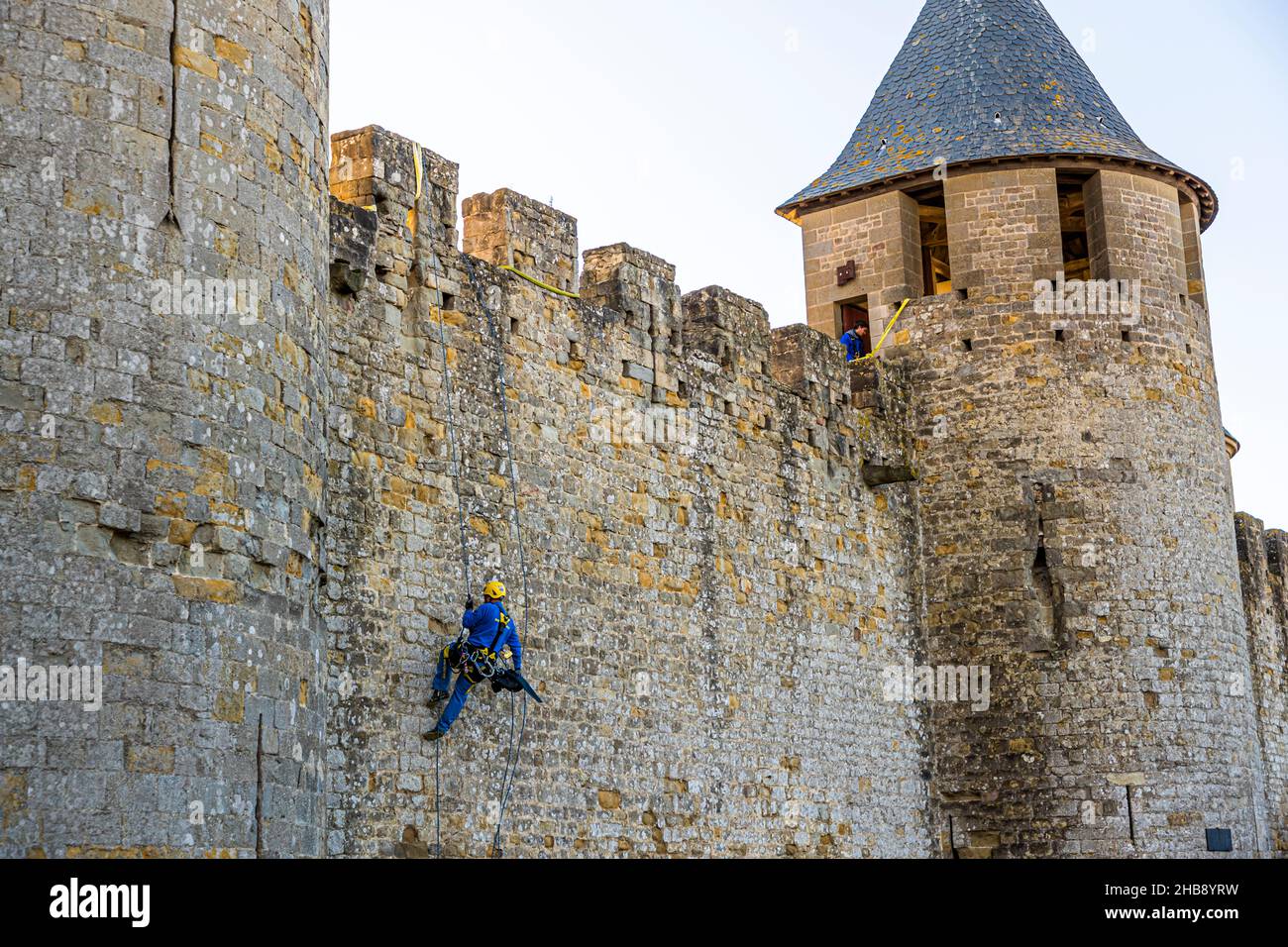 Facade climber inspects the old city wall of Carcassonne, France Stock Photo