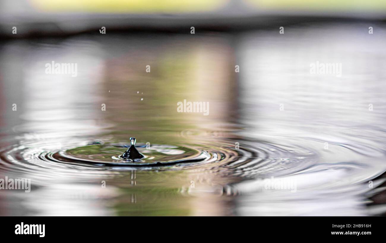 Closeup of the water droplet falling into the water Stock Photo - Alamy