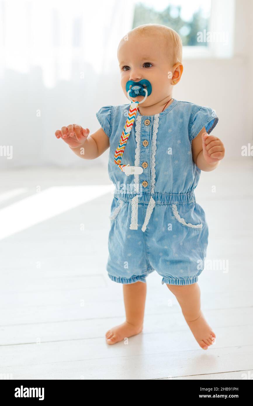 Very cute and funny baby in denim sarafan make first steps. Smiling little girl learning to walk. Concept of kids growth and happy childhood Stock Photo - Alamy Very cute and funny baby in denim sarafan make first steps. Smiling little girl learning to walk. Concept of kids growth and happy childhood Stock Photo - Alamy