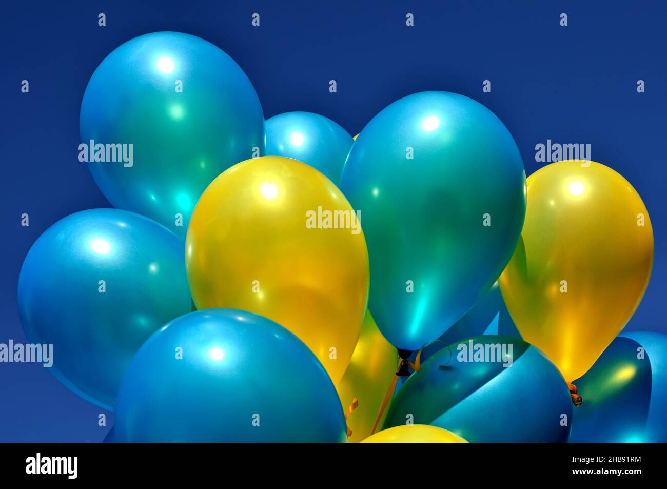 blue and yellow metallic balloons in the city festival against deep blue sky Stock Photo