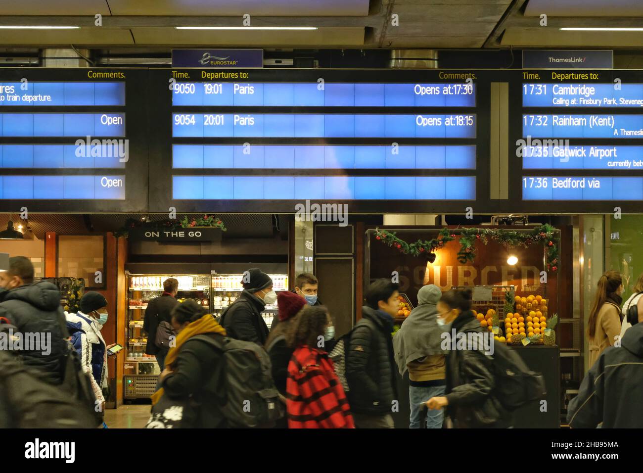 London, UK, 17th, Dec, 2021. Travellers queue in front of a departure board as they rush to leave London via St Pancras Eurostar services ahead of France's non-essential travel ban coming into force after 11pm GMT and at midnight Paris time. The restrictions are a move to stop the spread of Omicron infections as the UK records 93,045 coronavirus cases today. After midnight, non-citizens and non-residents must provide a 'compelling reason' in order to enter France from the UK. Credit: Eleventh Hour Photography/Alamy Live News Stock Photo