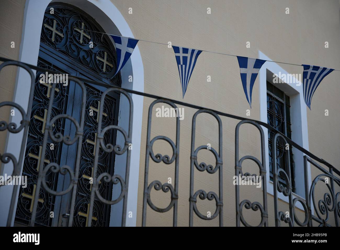 Traditional Greek Orthodox church exterior with an arched door, iron ...