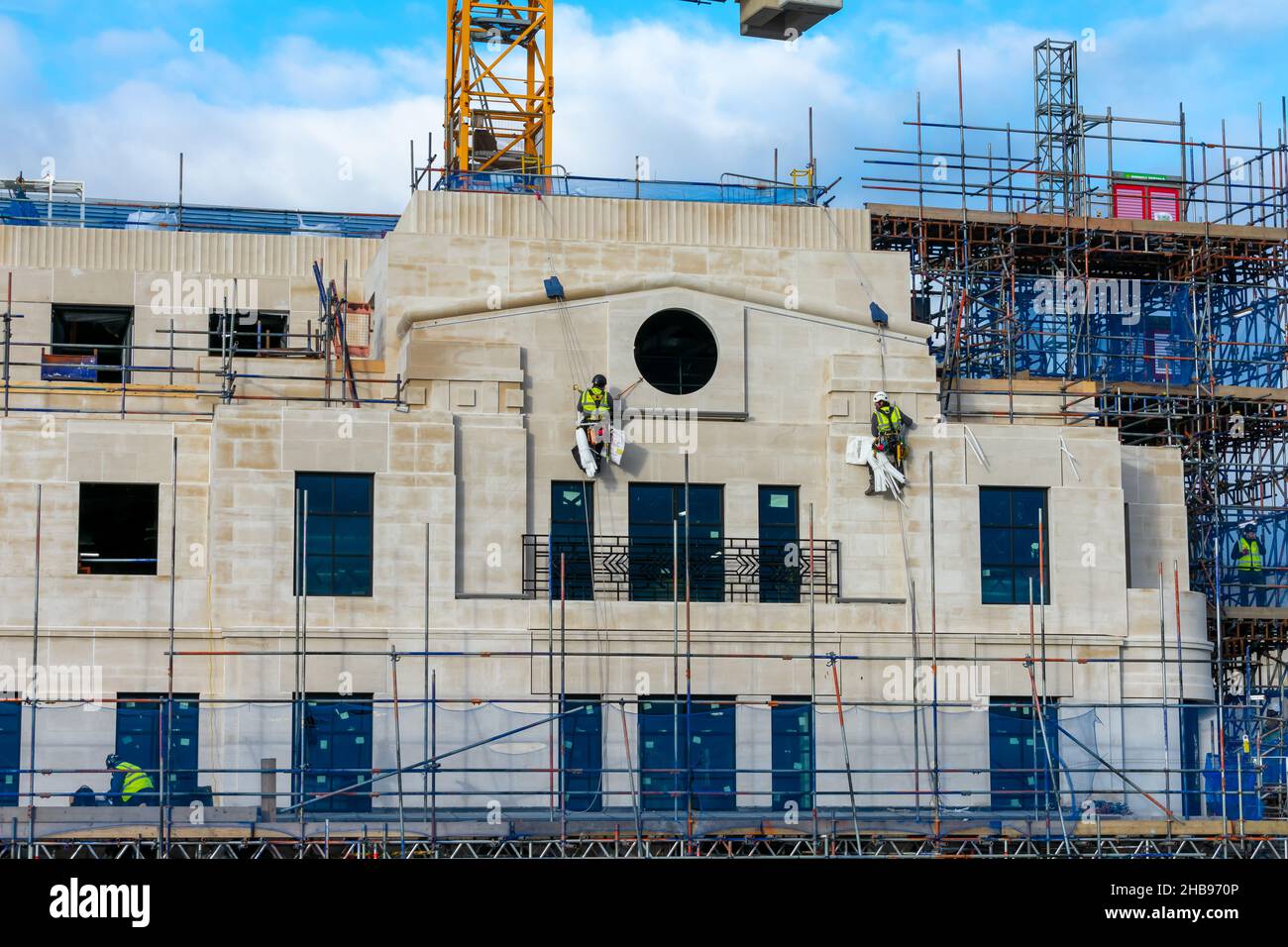 London. UK- 12.01.2021.Construction workers suspended on harness working on a tall building. Stock Photo