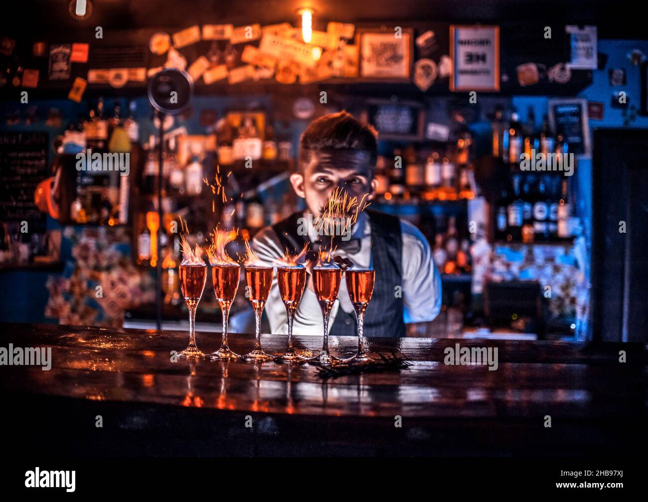 Charming bartender decorates colorful concoction Stock Photo