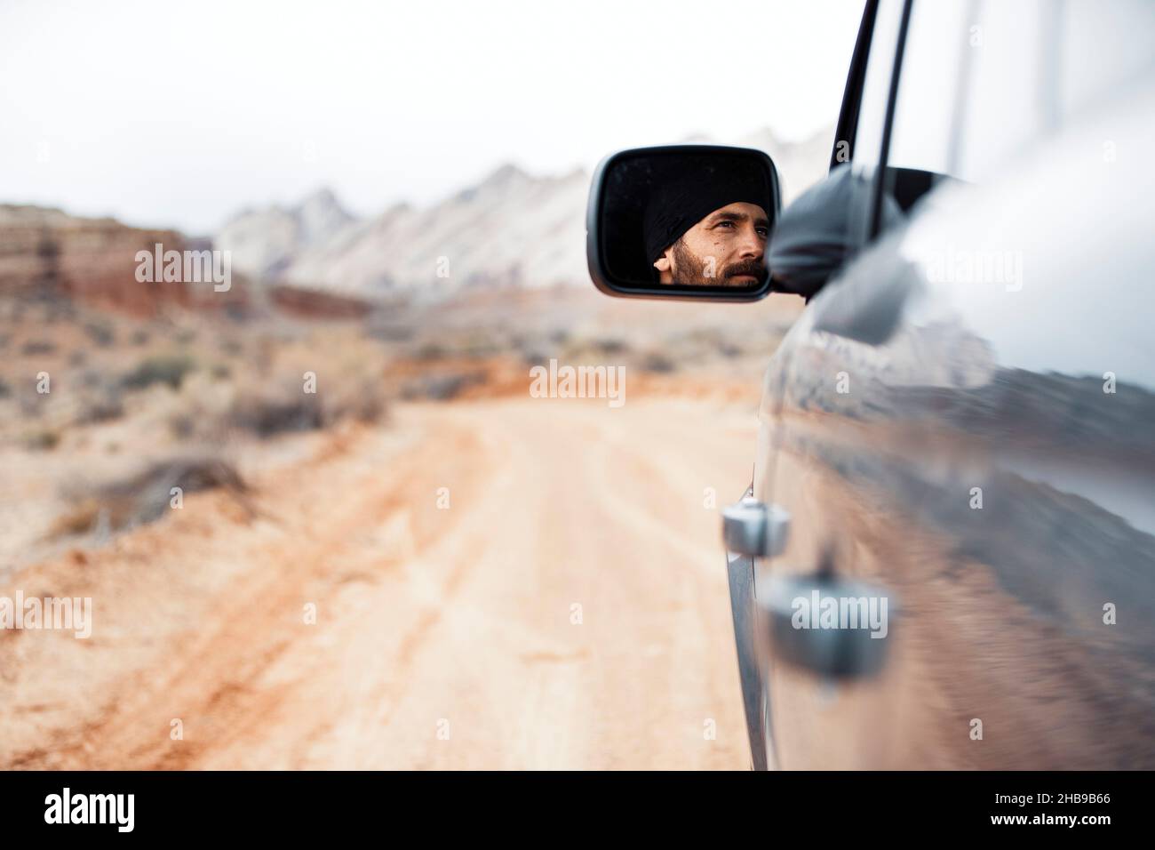 Man driving in Utah, facial view from side mirror Stock Photo