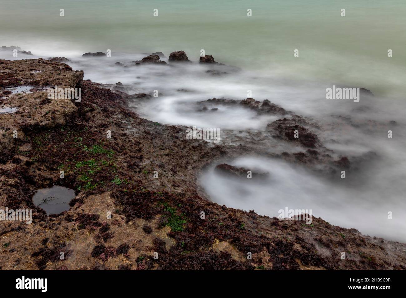 abstract coastal rocky and rugged shoreline of the isle of wight coast, mysterious swirling seas and rugged rocks on isle of wight coastline. Stock Photo