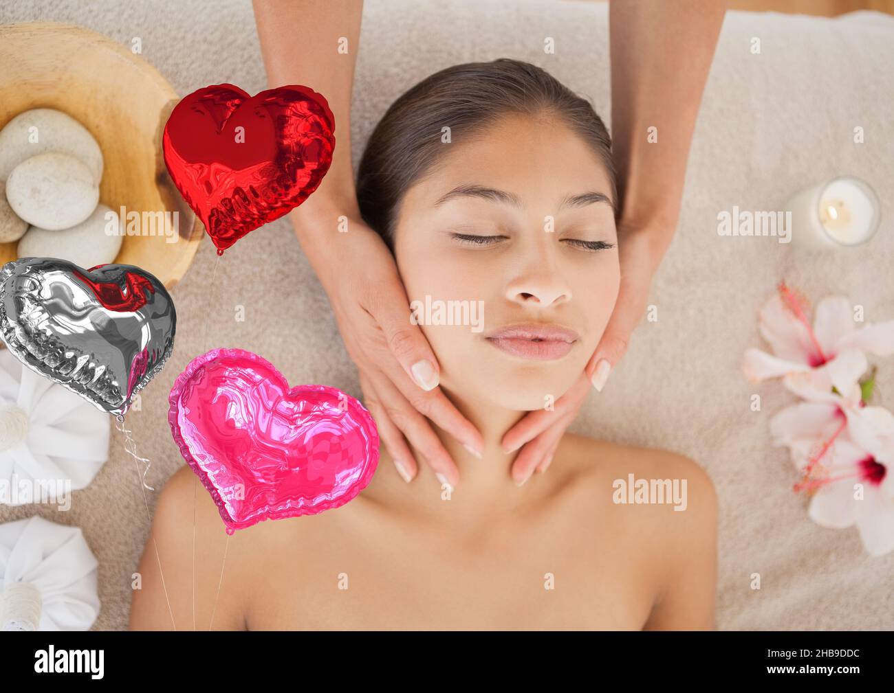 Composite image of red heart shaped foil balloons against woman receiving a neck massage at a spa Stock Photo