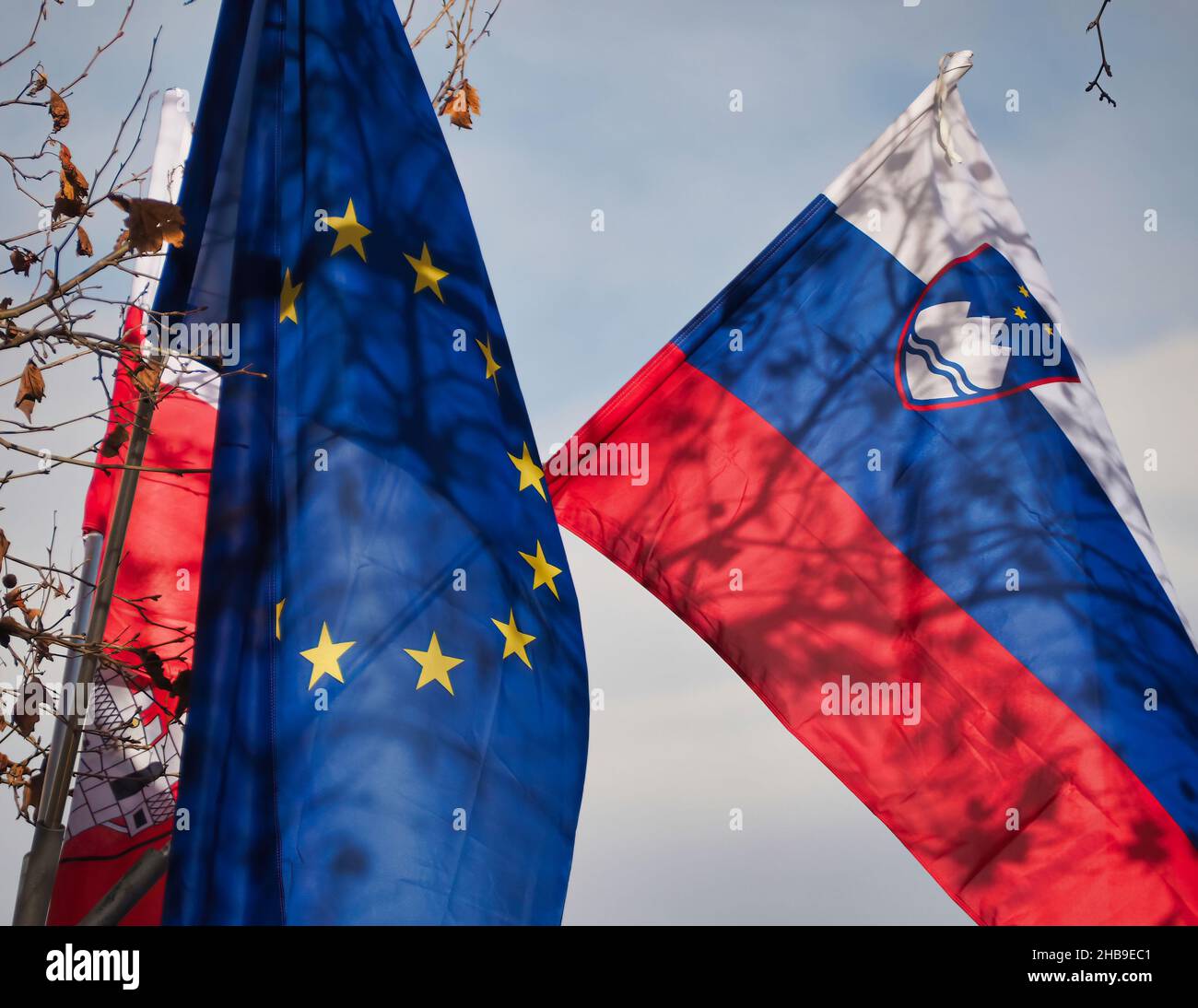EU flag and the flag of Slovenia in the air Stock Photo
