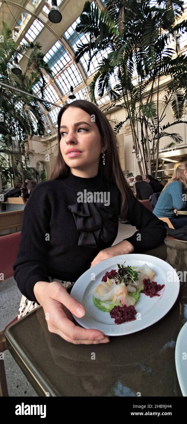 Young female in a Palmenhaus restaurant in Austria Stock Photo
