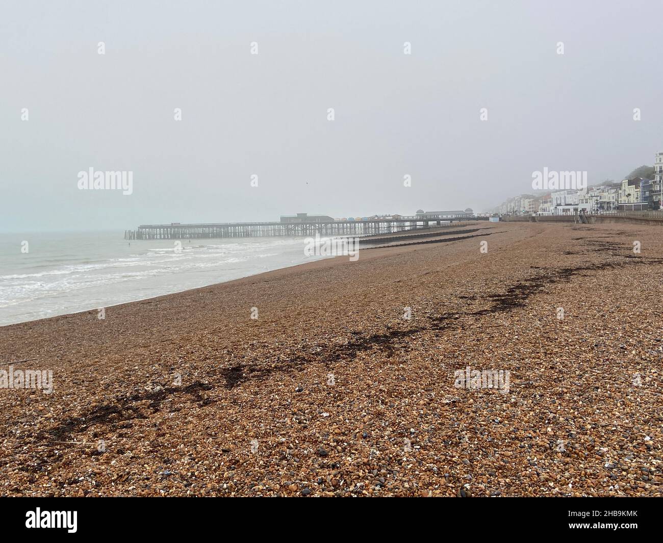 Hastings beach pier and seafront at sunset one man silhouette on