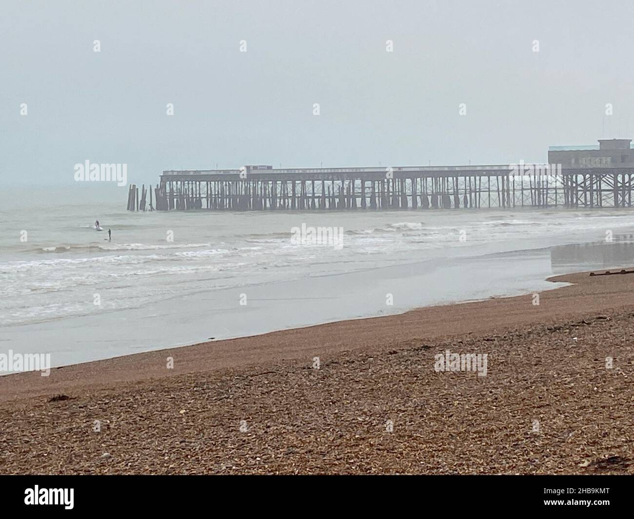 Hastings beach pier and seafront at sunset one man silhouette on