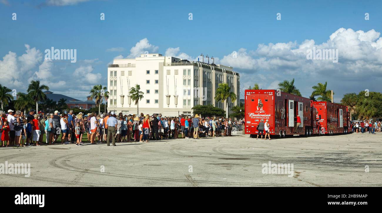 crowd awaiting Clydesdale horses, Budweiser Brewery, promotional tour, 2 red trucks parked, preparing for team pulling wagon, people, all ages, antici Stock Photo