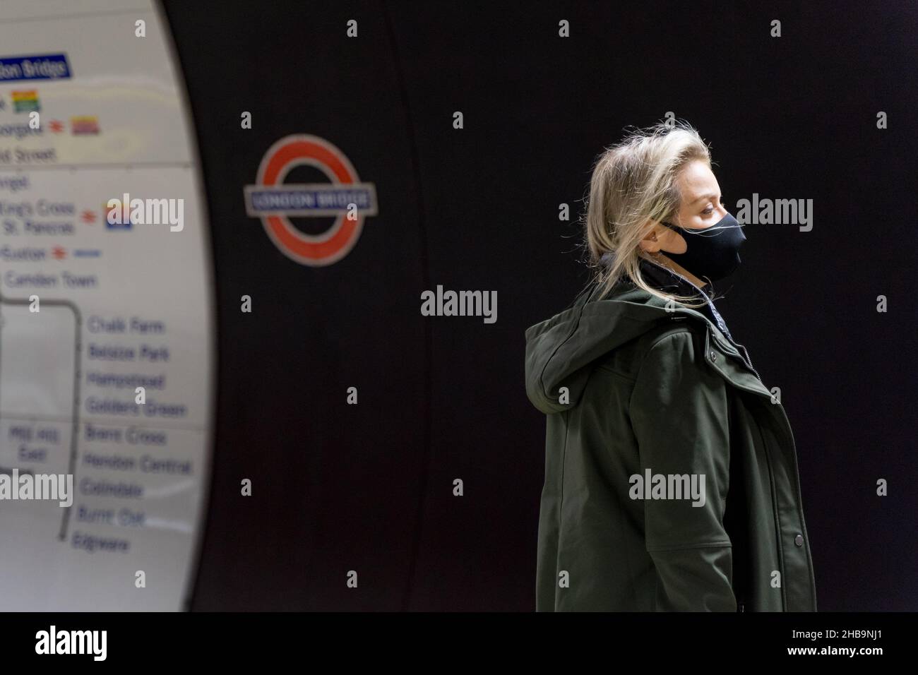 Tube Passenger in face mask look for train arrival time in London