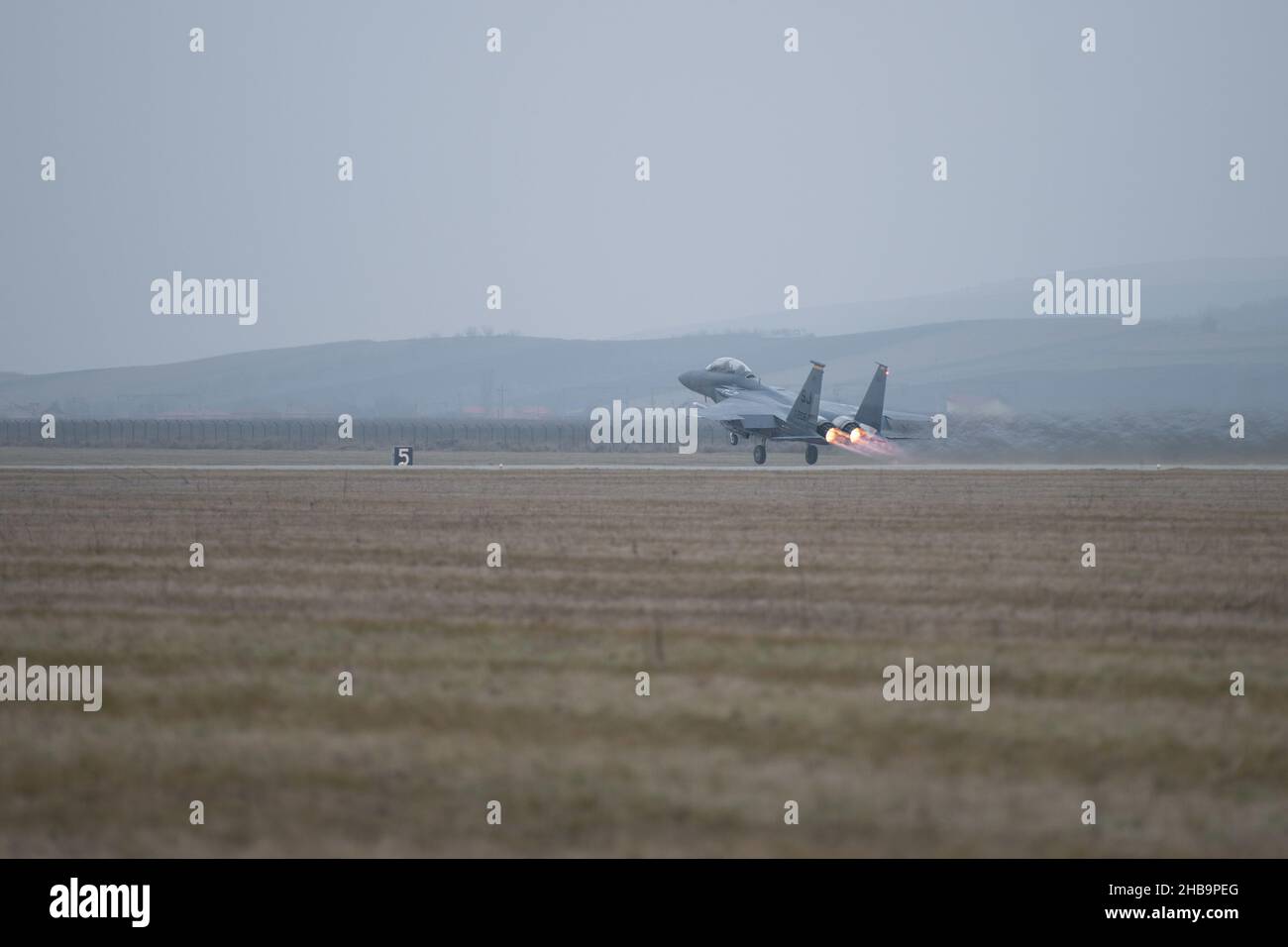 An F-15E Strike Eagle takes off from Campia Turzii, Romania, as a part of scramble certification training, Dec. 16, 2021.  As part of NATO’s Enhanced Air Policing mission, the aircrews require 24/7 alert response capabilities to respond to threats as a coalition force. (U.S. Air Force photo by Airman 1st Class Cedrique Oldaker) Stock Photo