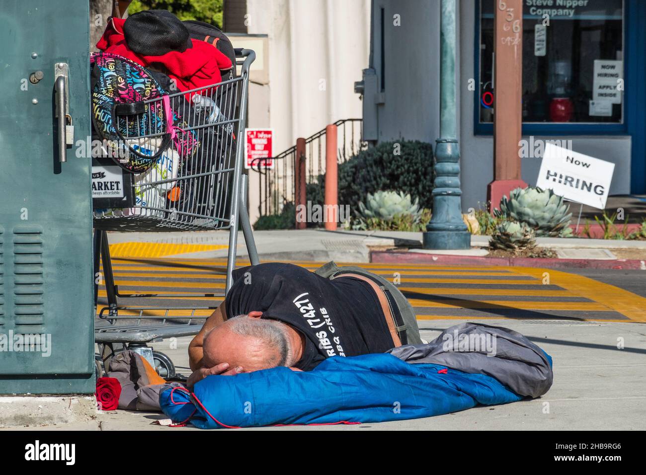 A homeless man sleeping on the sidewalk Stock Photo Alamy