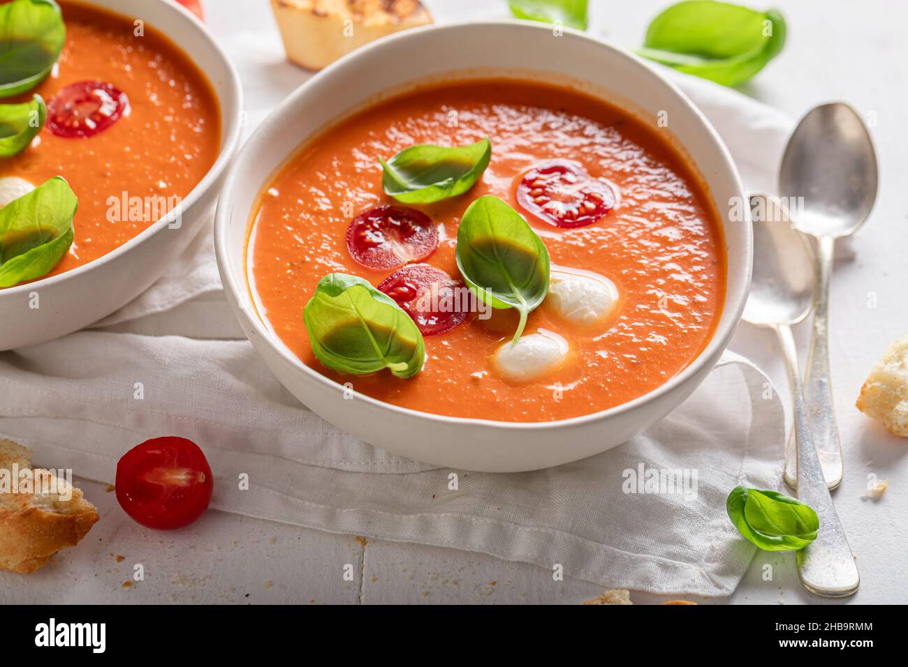 Red creamy tomato soup made of cherry tomatoes and basil. Tomato soup