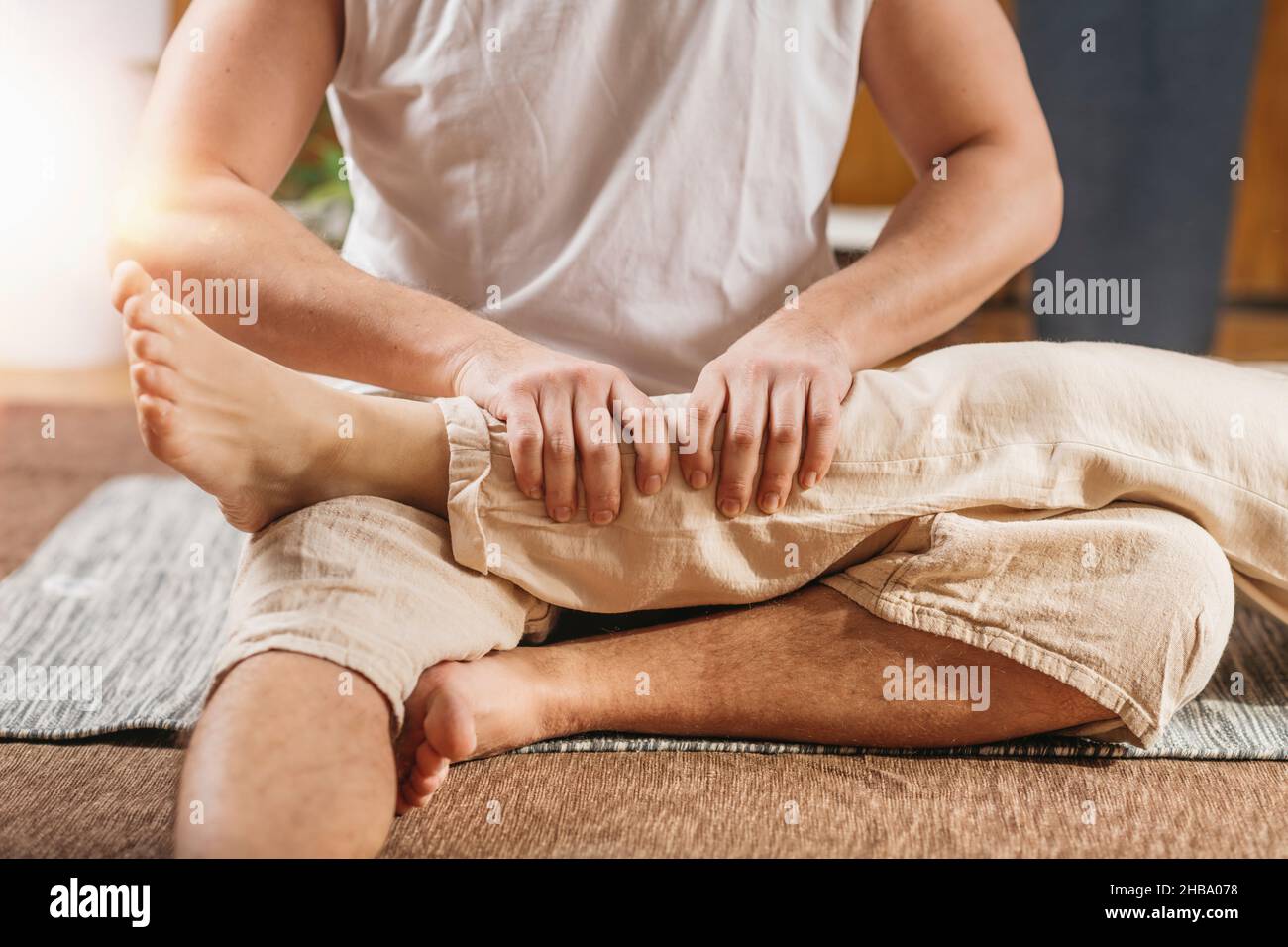 Thai body relaxing massage. Masseur giving a traditional Thai leg