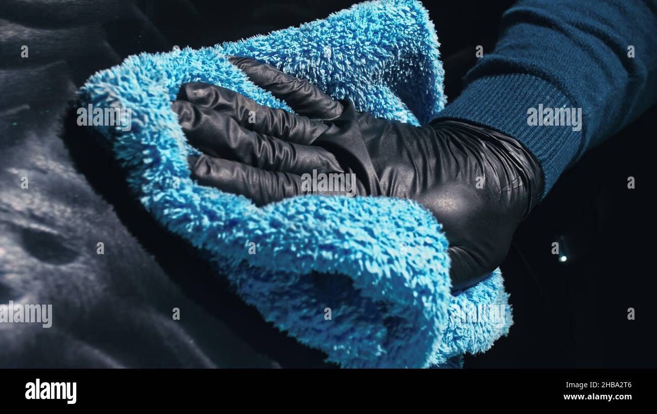 Using rag in palm of your hand, finish liquid car polish are removed