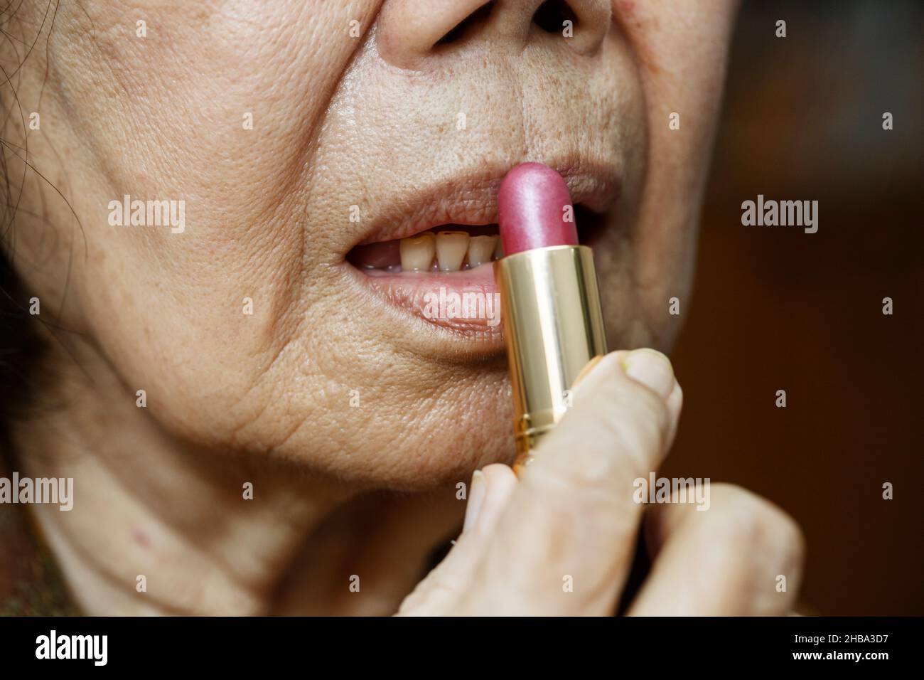 Elderly asian woman applied lipstick Stock Photo