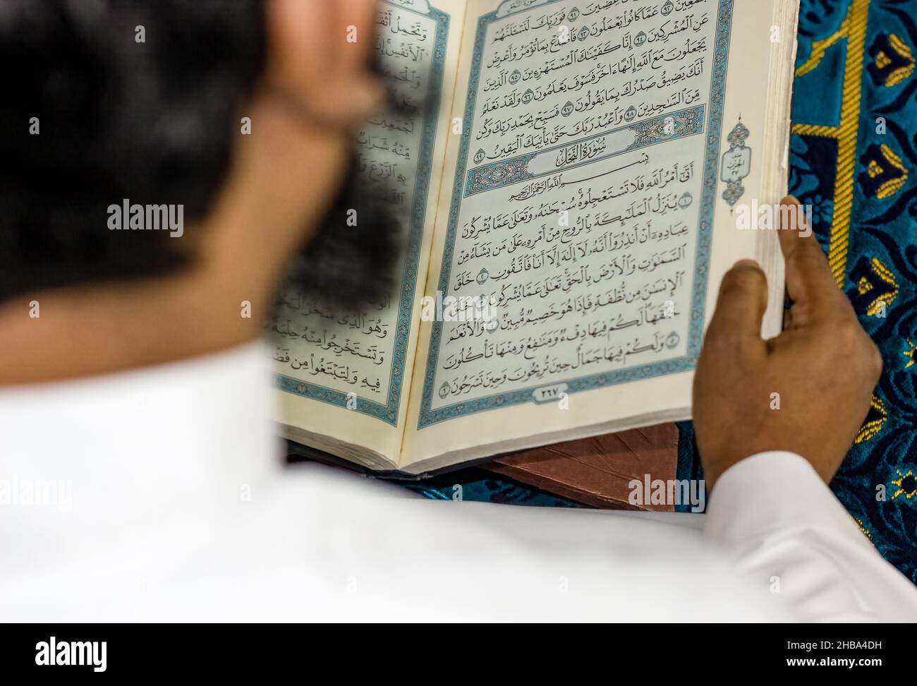A islamic scholar reading holy al quran inside of the mosque Stock Photo