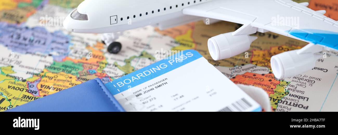Passport plane ticket and toy plane stands on world map closeup Stock Photo