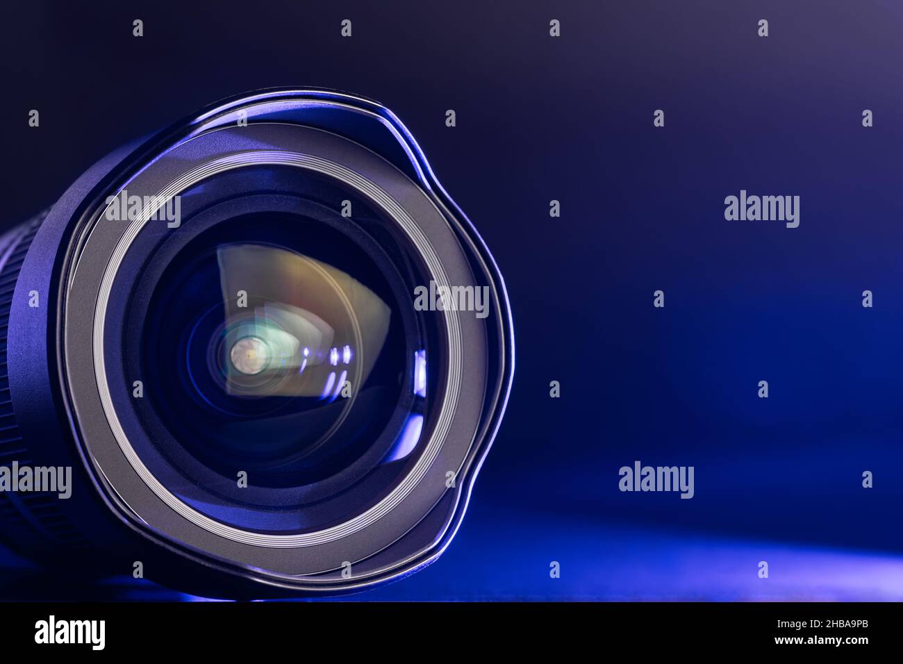The camera lens with blue light. Closeup of the camera lens on a black