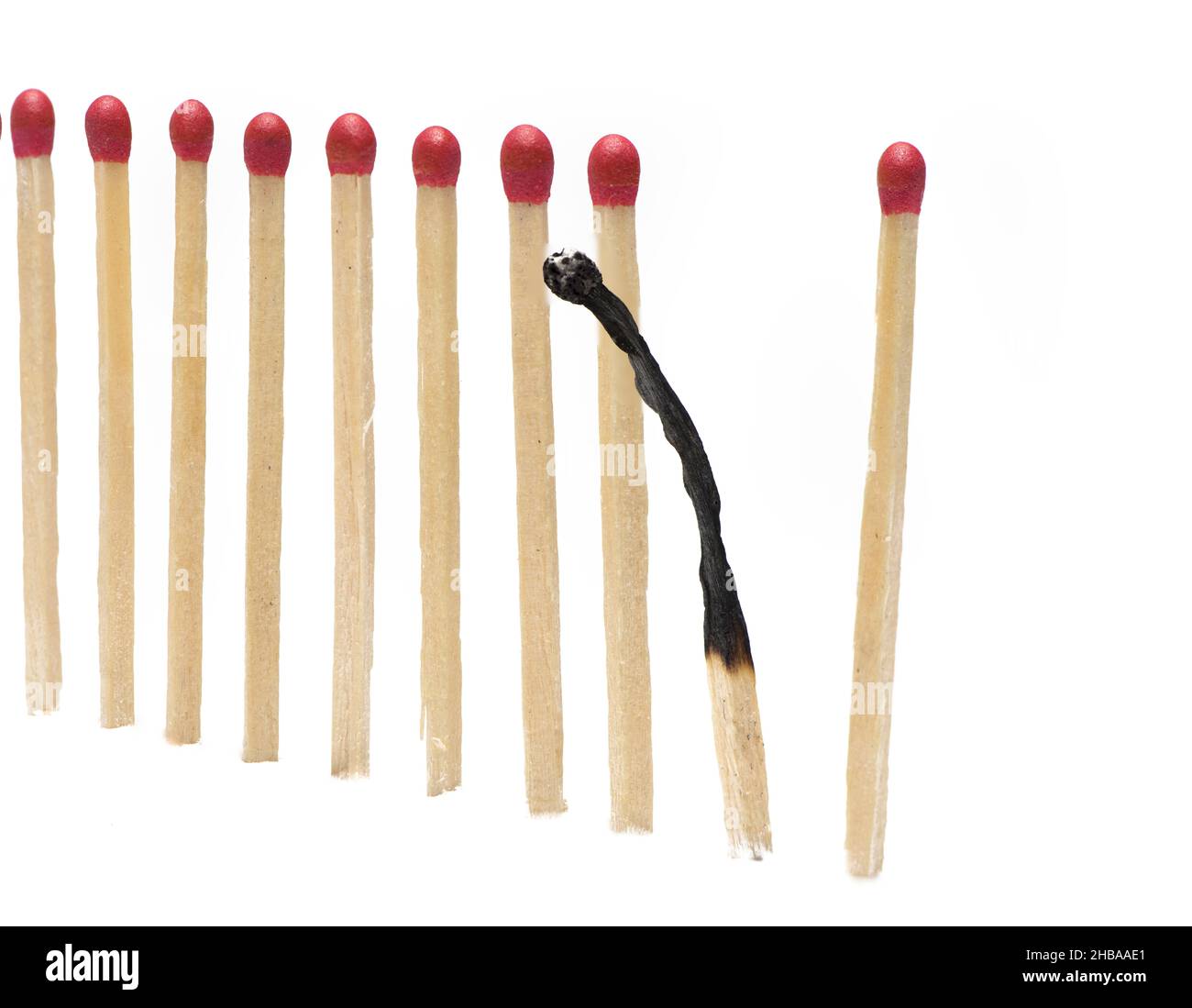 Close up of matches in an even row with a burned match behaving