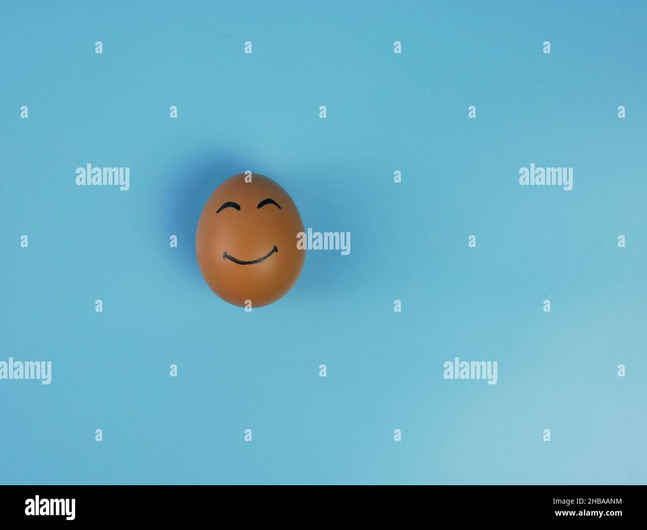 chicken egg with smiling face isolated on blue background Stock Photo ...