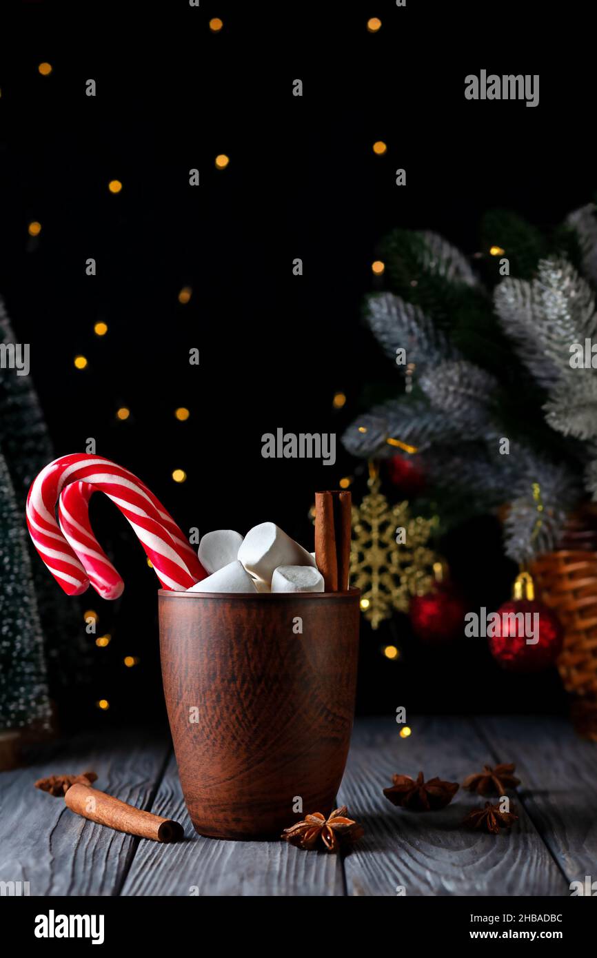 Marshmallow with caramel staff, cinnamon and a cup of latte on the background of a christmas tree Stock Photo