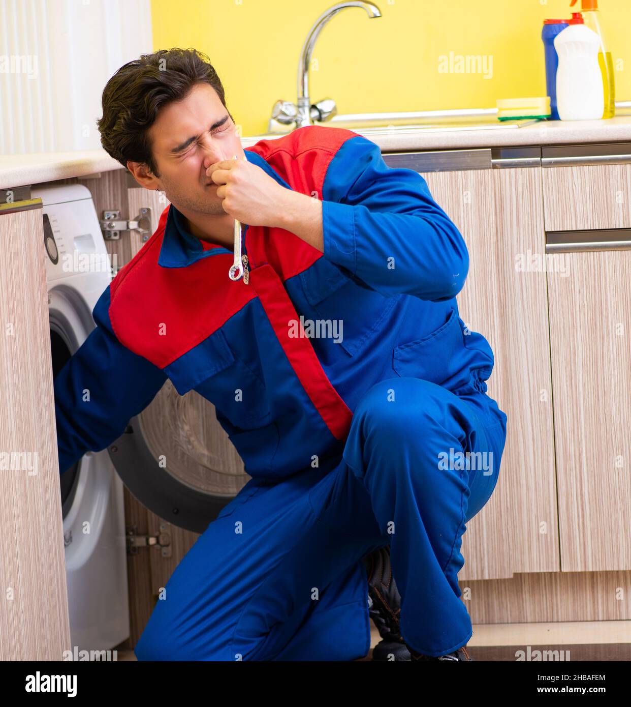 The repairman repairing washing machine in the kitchen Stock Photo Alamy
