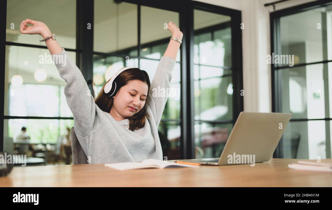 A teenage girl wears headphones with her arms up to relax during an online class, a teenage girl relaxes while using a laptop, an Asian girl sleeps wi Stock Photo