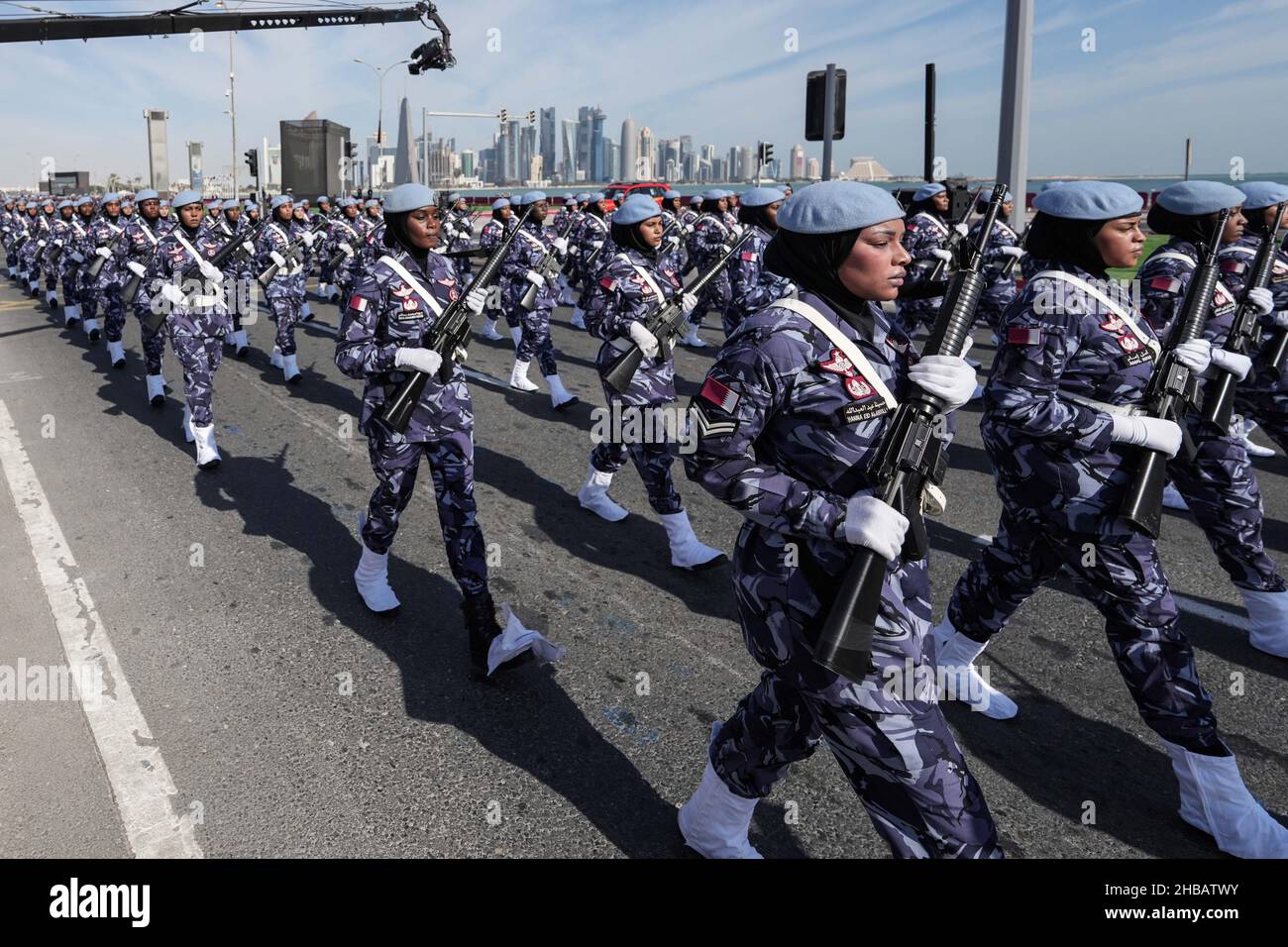 Doha, Qatar. 18th Dec, 2021. Armed policewomen in uniform march on a