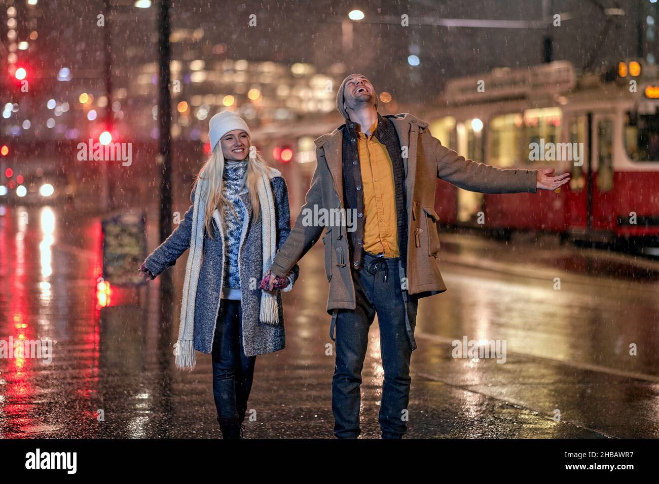 Joyful couple walking together on the street; Christmas joy concept Stock Photo