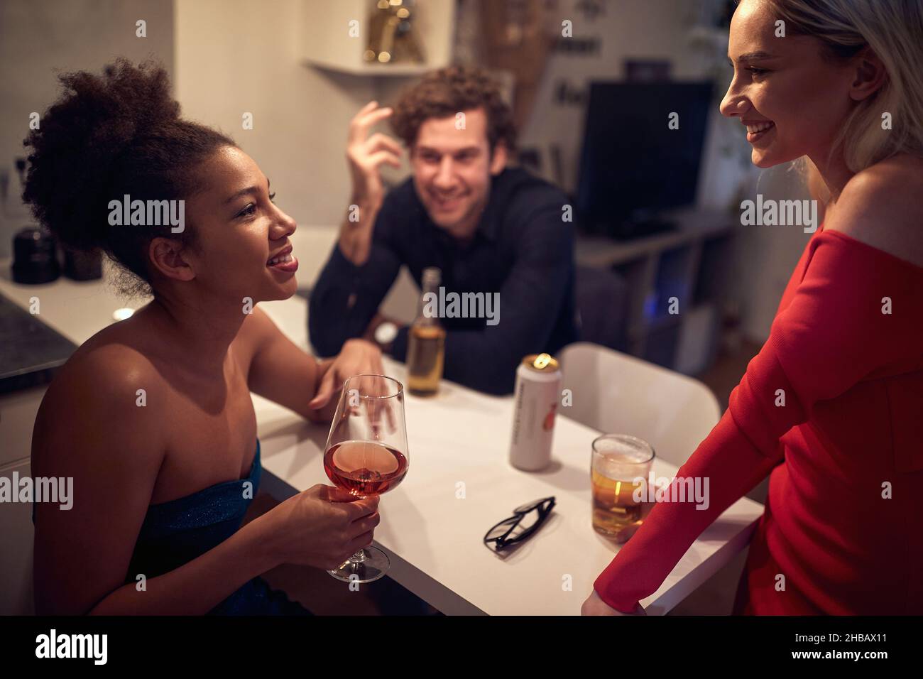 Group of festive friends celebrating the New Year together indoors; Private party concept Stock Photo