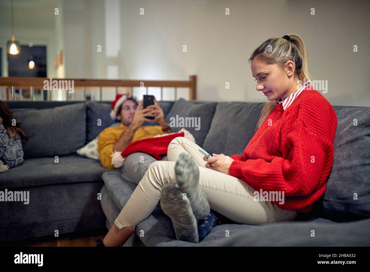 Bored Christmas. Young Couple online with smartphones. Stock Photo