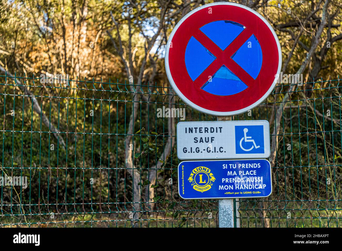 Parking space reserved for disabled people. A sign put up by the Lions Club says: If you take my place, take my disability too. Bormes-les-Mimosas, France Stock Photo