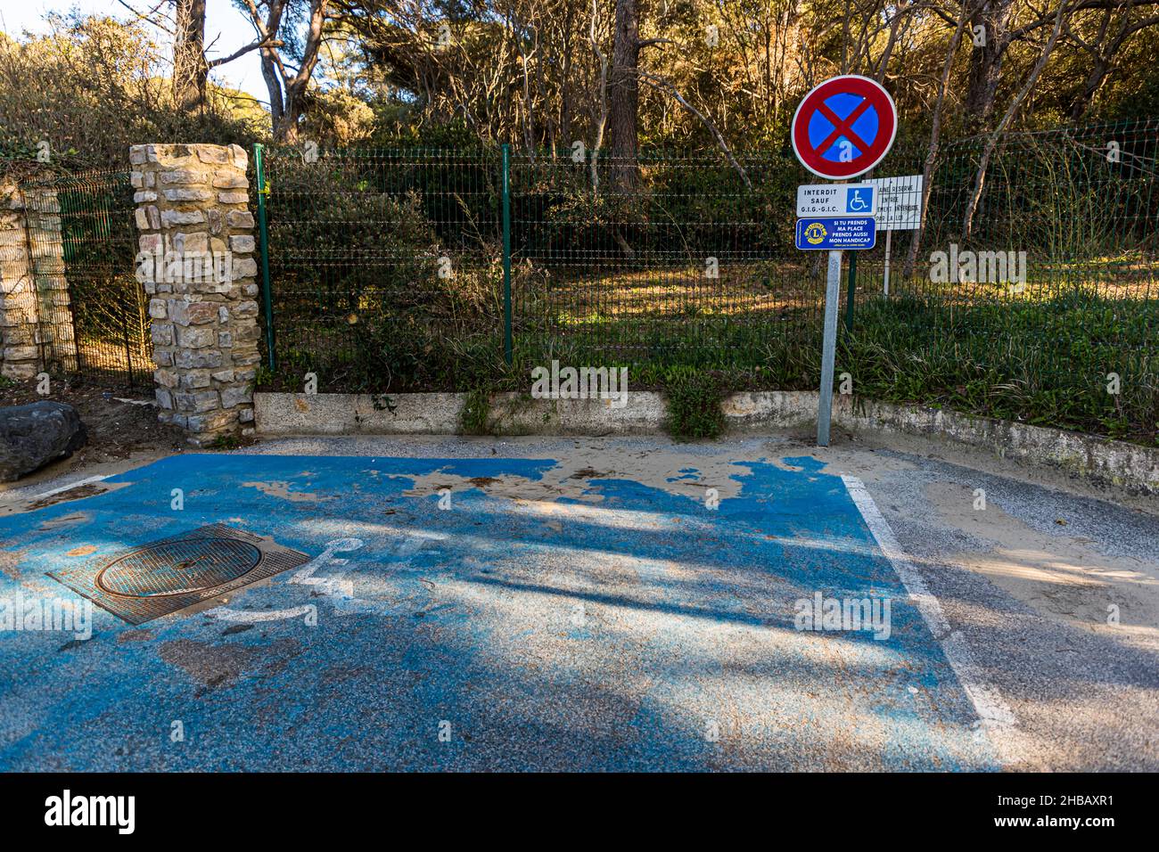 Parking space reserved for disabled people. A sign put up by the Lions Club says: If you take my place, take my disability too. Bormes-les-Mimosas, France Stock Photo