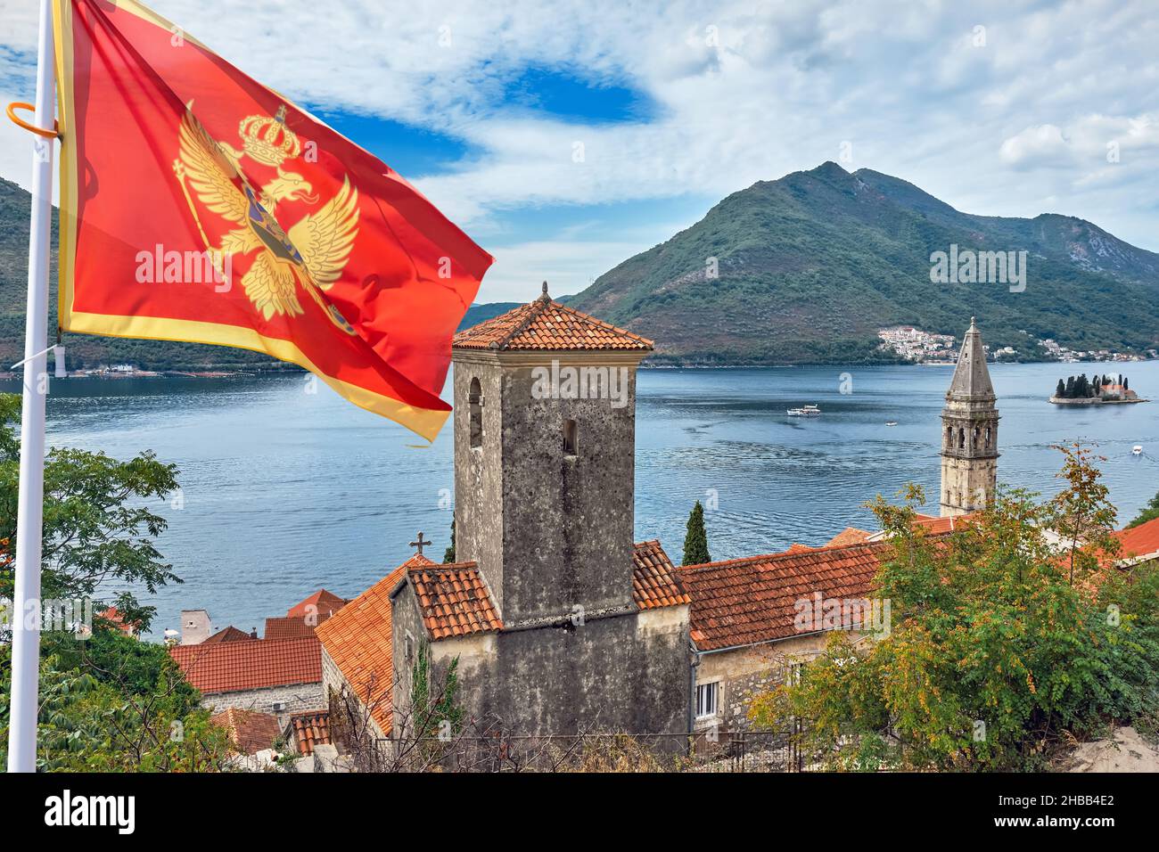 View of Church of St. Matthew in Dobrota, small town located on the coast between Kotor and Perast, with the Montenegro flag. Stock Photo
