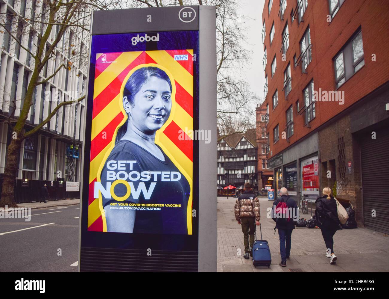 London, UK 18th December 2021. People walk past an electronic display in Central London urging everyone to get a booster vaccine as the Omicron variant of COVID-19 spreads in the UK. Credit: Vuk Valcic / Alamy Live News Stock Photo